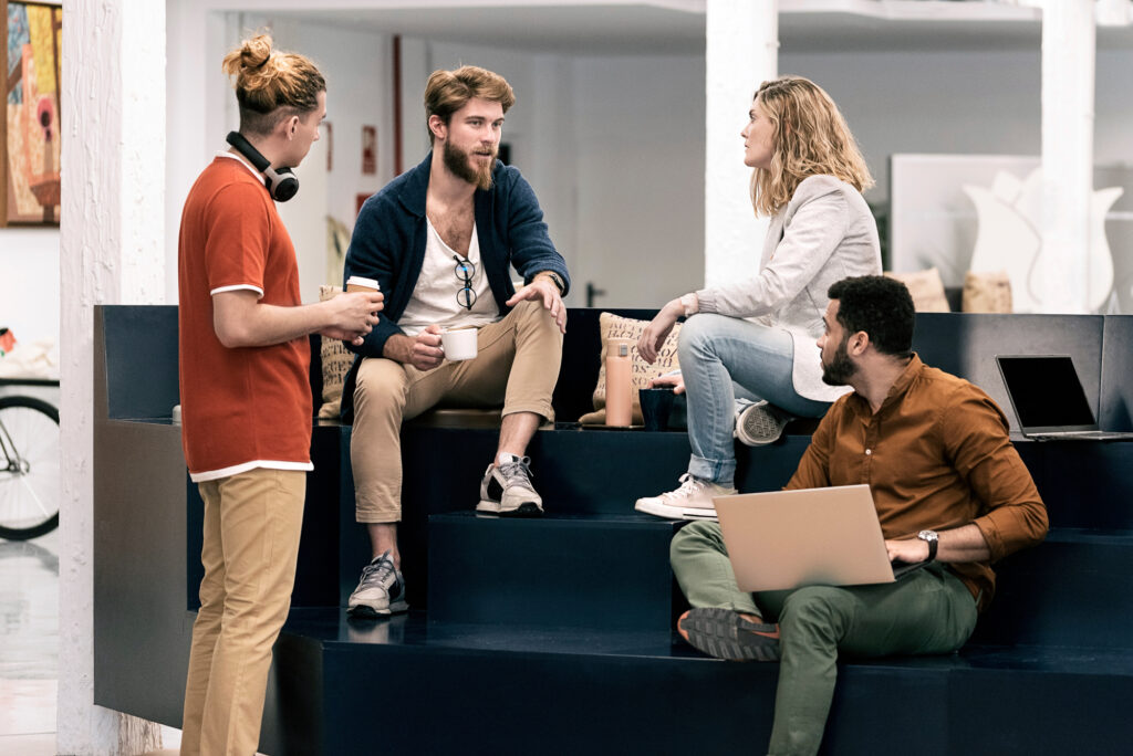 Stock photo of young work team working and talking in a modern bright office. Coworking concept.