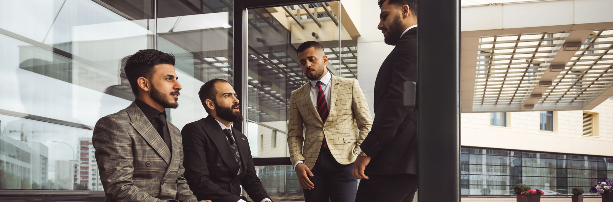 Business partners jointly discuss the difficulties and the implementation of ideas. Young successful men in suits at a team meeting outside the office.
